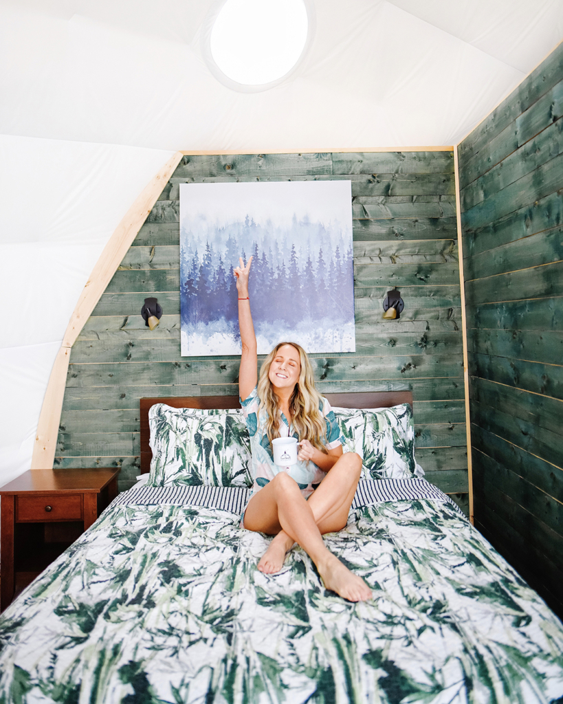 Halifax Blogger poses on a bed in pjs in a glamping dome